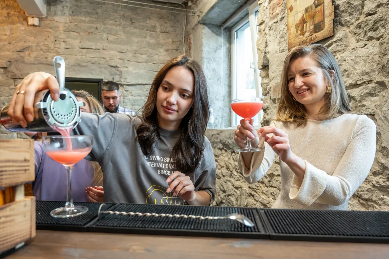 Participants raising their finished cocktails in coupe glasses