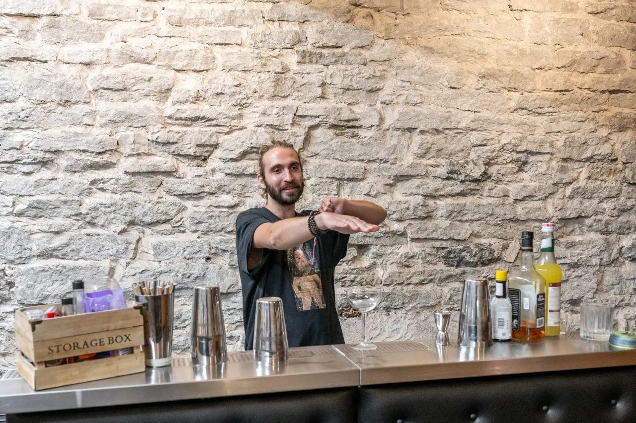The bartender behind the counter with the cocktail tools