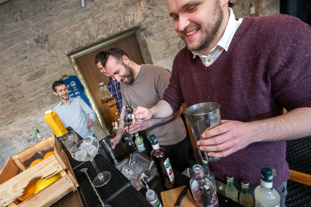 Two participants shaking cocktails and laughing during the workshop