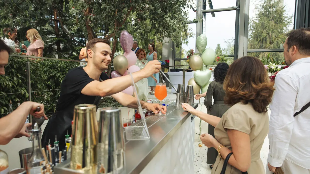 A Bartender’s bartender handing a freshly made cocktail to a guest across the counter