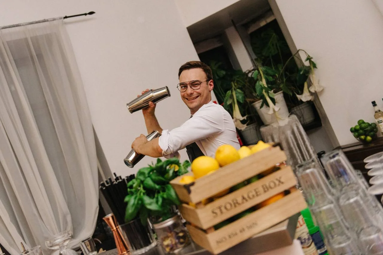 A bartender with a crate of fresh citrus at a home party
